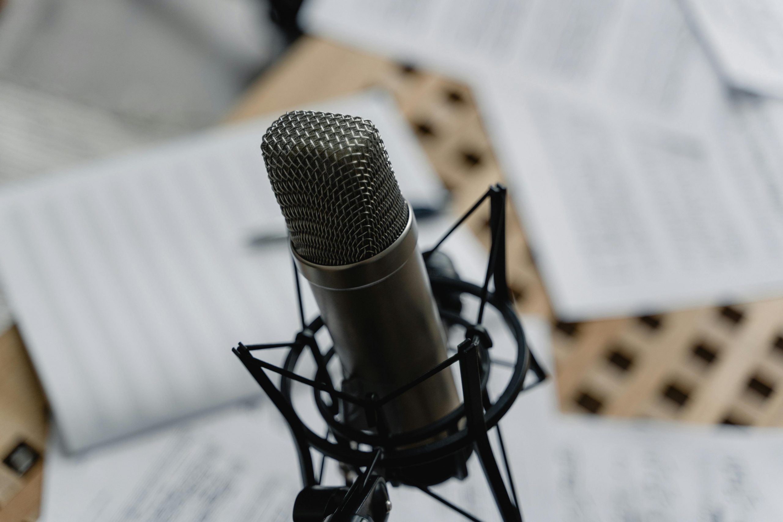 pexels-tima-miroshnichenko-6671687 a microphone surrounded by scripts showing why it is best to choose a human voice for your project